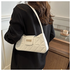 Detalle de bolso crema con costuras geométricas acolchadas y hebilla metálica dorada