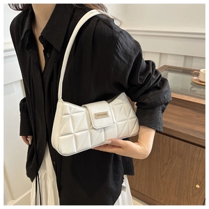 Detalle de bolso baguette blanco acolchado en piel sintética con hebilla metálica dorada