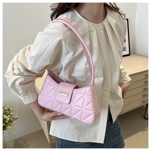 Detalle de bolso baguette acolchado rosa con hebilla dorada y correa de cuero