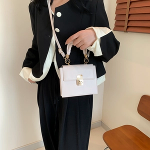 Fashionable light pink mini square crossbody bag with gold buckle and silk handle detail