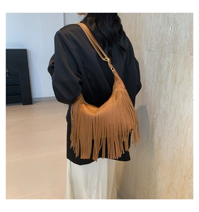 Close-up of a brown hobo bag featuring dense long tassels and gold metal hardware