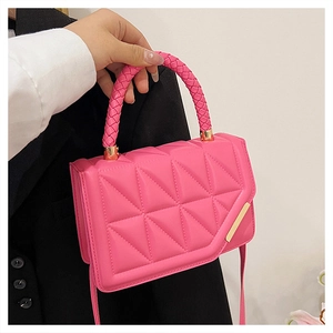 Detailansicht der rosaroten Handtasche mit gesteppter Textur und goldenen Beschlägen