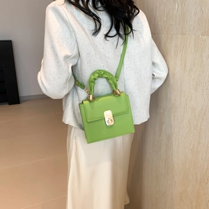 Neon green leather crossbody bag with cloud pleated handle and gold clasp on model