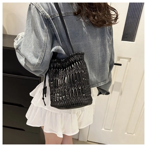 Détail d'un sac à main seau matelassé noir avec cordon de serrage en bandoulière