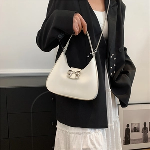 Borsa a spalla bianca a mezzaluna con fiocco argento e tracolla a catena su modella
