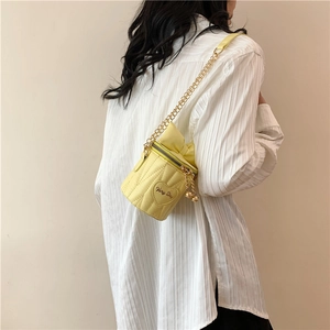 Sac seau jaune matelassé avec broderie cœur et détail nœud porté à l'épaule