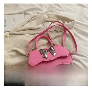 Detail of bright pink square handbag with wavy edge and silver metal bow buckle