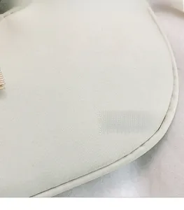 Close-up of the high-quality cream canvas fabric texture on this stylish shoulder bag