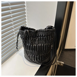 Gros plan du sac seau noir plissé avec fermeture à cordon et fine bandoulière en cuir