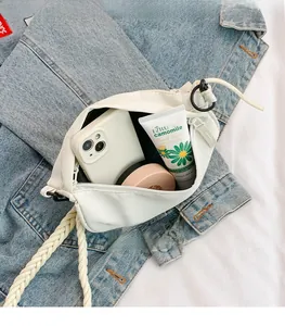 Detailed view of spacious interior of white canvas crossbody bag with thick woven strap