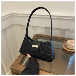 Detalle del bolso de hombro acolchado negro con hebilla dorada y elegante patrón de rombos