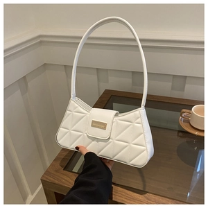 Detalle del bolso de hombro acolchado blanco con hebilla de metal dorado sobre mesa de madera