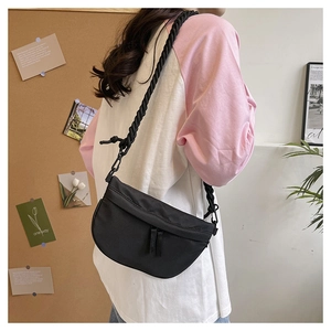 Detail of a black crescent nylon crossbody bag with unique woven rope shoulder strap