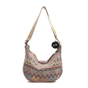 Sac à bandoulière tissé bohème avec motifs zigzag colorés et pendentif peluche sur fond blanc