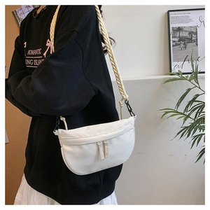 Detail of white crescent crossbody bag with distinctive cream rope braided shoulder strap