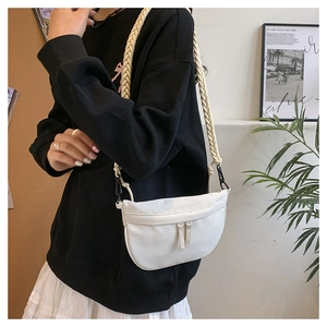 Detail of white half-moon nylon bag with aesthetic braided strap and dual zippers