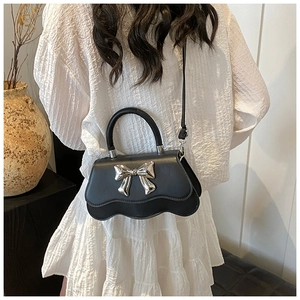 Elegant black bow shoulder bag with wavy edge design and silver metallic bow detail