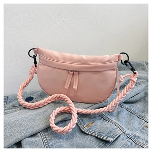 Detailed view of pink nylon crescent bag with woven rope strap on blue denim background
