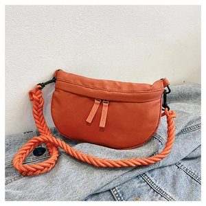 Detail of orange crescent crossbody bag featuring thick woven rope strap and dual zippers