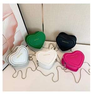 Close-up of mini heart-shaped crossbody bags in multi-color PU leather with chain straps