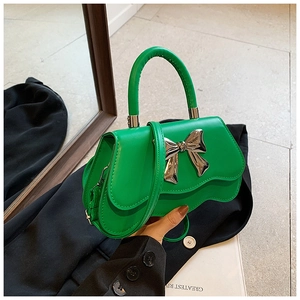 Detail of lime green handbag with silver metal bow and unique wavy bottom edge