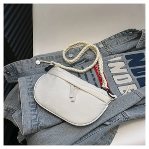 Detail of white half-moon canvas bag with thick woven rope shoulder strap on denim background
