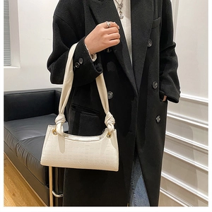 White crocodile pattern shoulder bag with knotted strap and gold metal eyelet detail