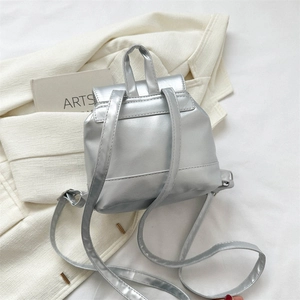 Détail du dos du mini sac à dos argenté avec poignée supérieure et bretelles fines