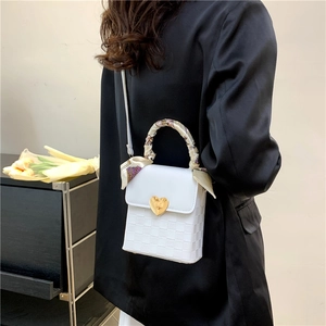 White woven crossbody bag with golden heart lock and silk scarf handle decoration