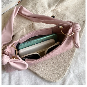 Internal view of pink crocodile pattern handbag showing storage for phone and sunglasses
