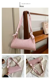 Pink crocodile pattern underarm bag with knotted strap and gold ring detail