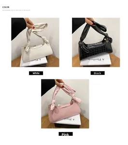 Detailed display of crocodile pattern bags in white, black and pink with knotted handle