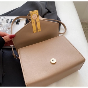 Detail of khaki lychee grain leather crossbody bag with gold magnetic buckle and strap