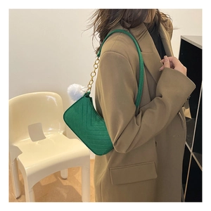 Bolso de hombro verde con acolchado en V, cadena dorada y detalle de pompón blanco