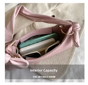 Close-up of the internal capacity showing the pink crocodile pattern shoulder bag interior