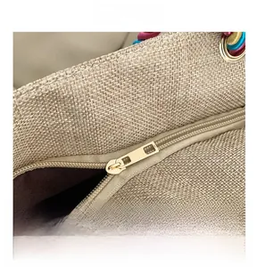 Detail shot of smooth golden metal zipper and colorful woven handles on ethnic tote bag
