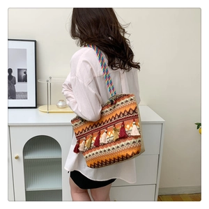 Ethnic bohemian tote bag featuring colorful tassels and rainbow woven handles on model