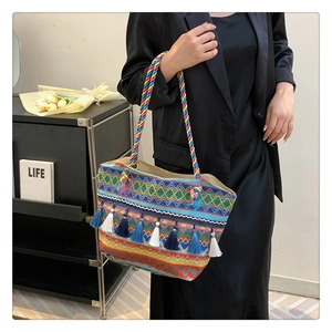 Detailed close-up of bohemian woven tote bag with colorful fringe and handle detail