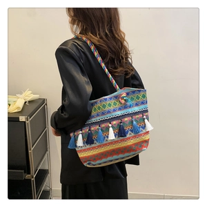Detailed shot of ethnic woven tote bag featuring vibrant tassels and colorful textures