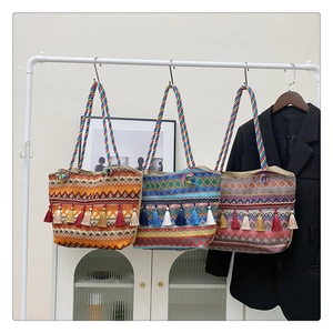 Three bohemian woven tote bags with tassels and colorful handles in orange blue and purple