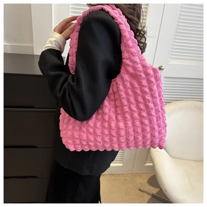 Close-up of pink bubble texture tote bag on model shoulder with black blazer