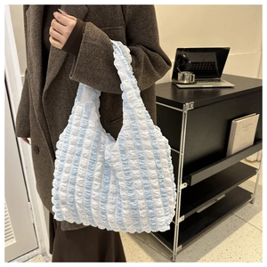 Gros plan sur la texture bouffante à rayures bleues et blanches d'un grand cabas
