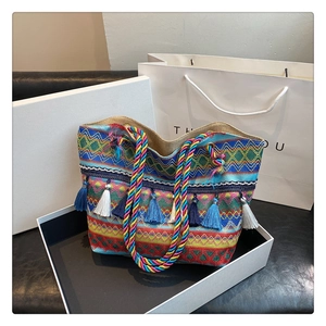 Detail of bohemian woven tote bag with vibrant geometric patterns and colorful tassels
