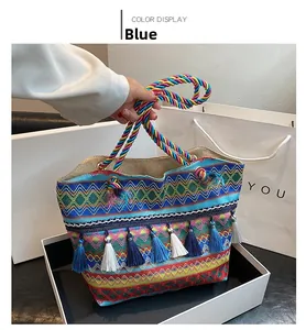 Detail of bohemian tote bag with colorful ethnic weaving and blue tassel accents