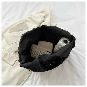 Top view of black ruched tote bag showing interior space with phone and umbrella