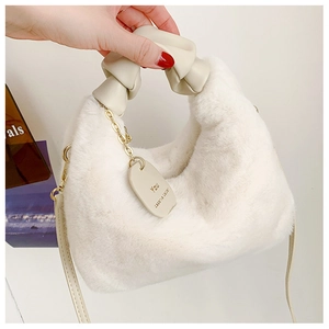 Détail du sac à main en fausse fourrure blanc cassé avec poignée froncée et chaîne