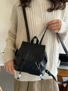 Petit sac à dos minimaliste en cuir noir avec cordon de serrage et logo mode ovale