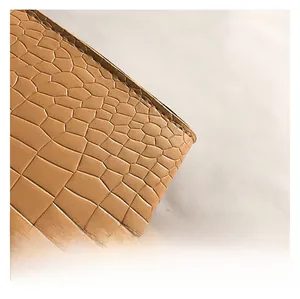 Macro shot of light brown crocodile pattern leather detail with high-quality stitching
