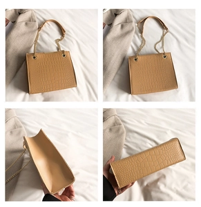 Close-up of crocodile pattern shoulder bag with golden chain strap and interior detail