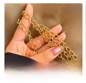 Close-up of high-quality gold metal chain strap with polished oval links on a handbag